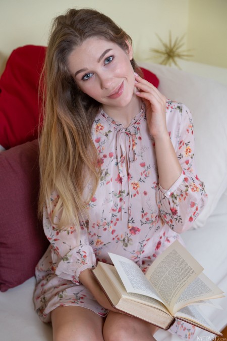 Девушка Геневьева Ганди читает книгу в кровати