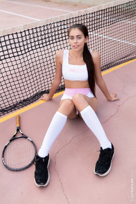 Соблазнительная теннисистка позирует в спортивной одежде