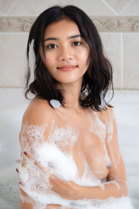 Счастливая девушка позирует голая в ванной